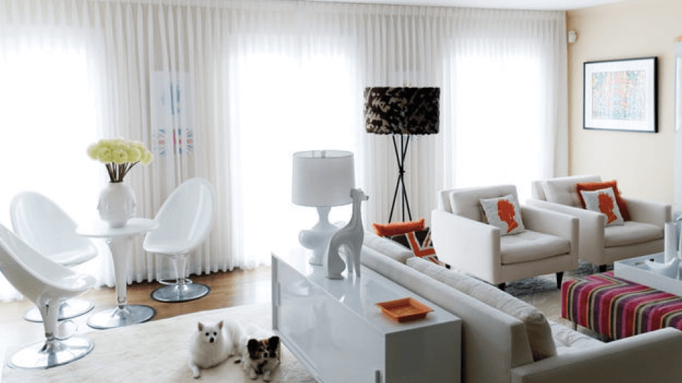 Living room with white furniture and red and orange accents