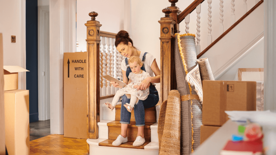 Mother and toddler sitting on the stairs with moving boxes