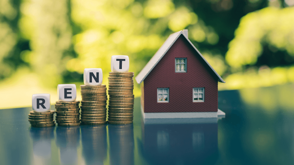 Stacked coins with rent spelled out and a red house