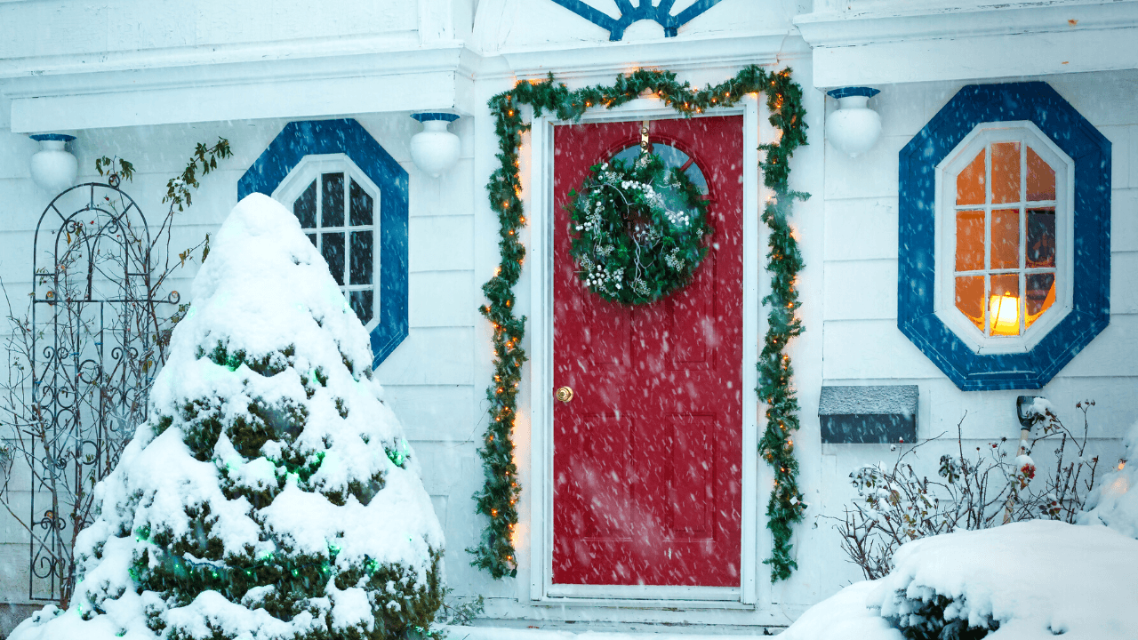 A red door with Christmas decor and Trees under the snow