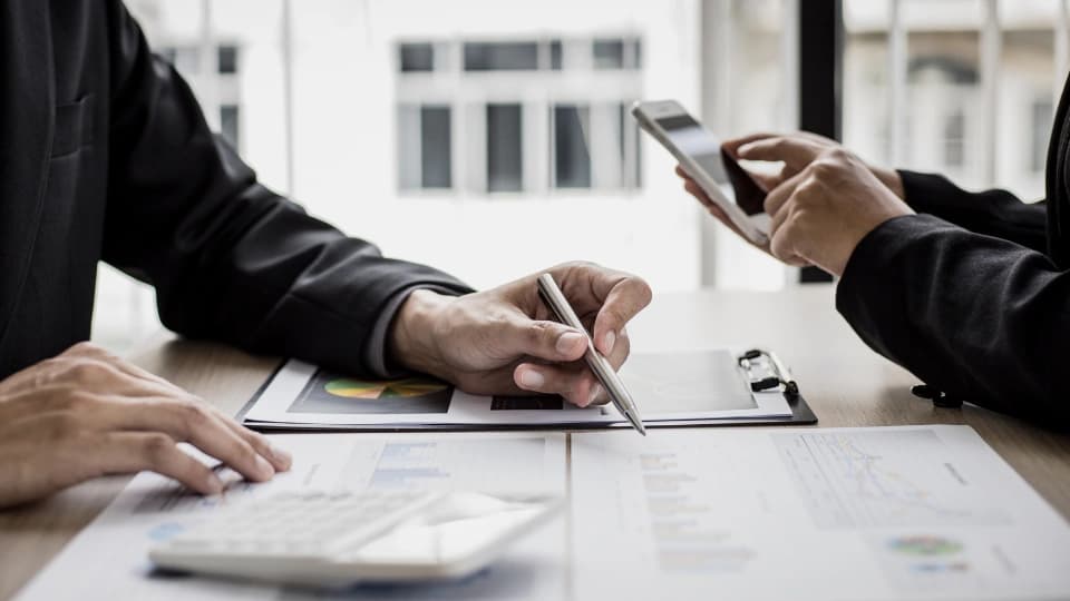 Person pointing at graphs on a tablet