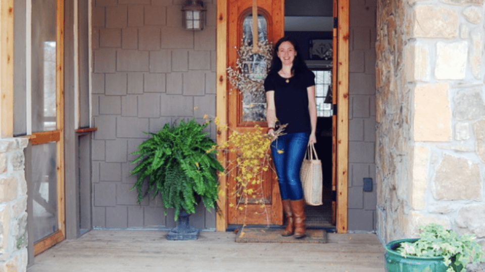 Woman standing next to home entrance