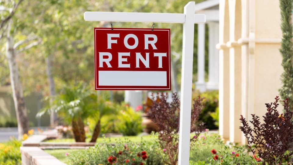 For rent real estate sign in front of house