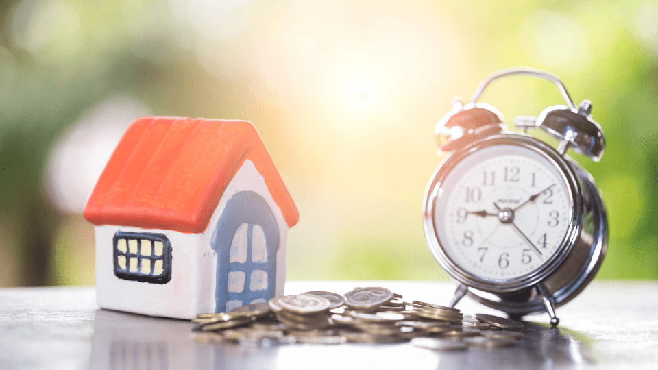 Small house with coins and a clock