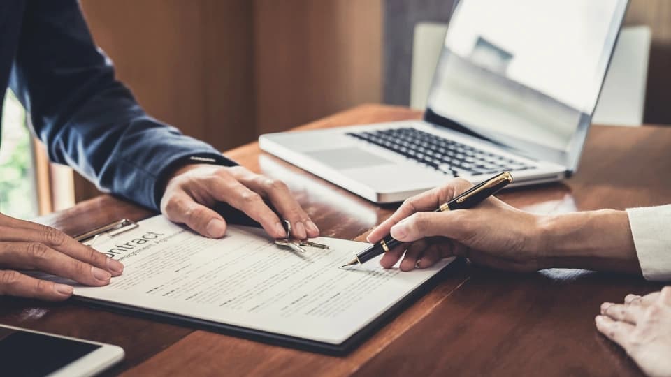 Two people looking at a contract on a clipboard