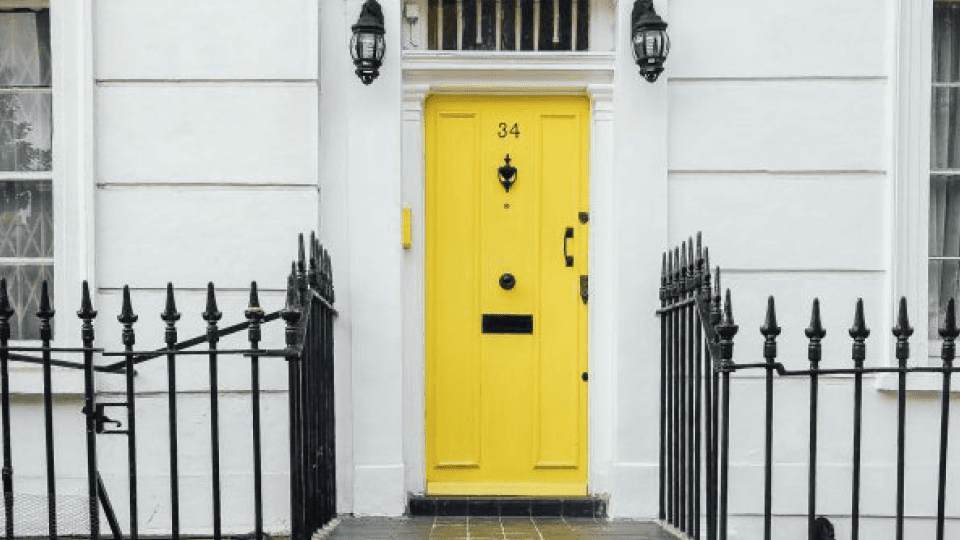 White house wall with yellow door