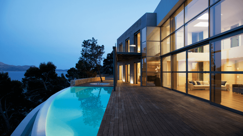Luxury real estate with pool and lake and trees on the background