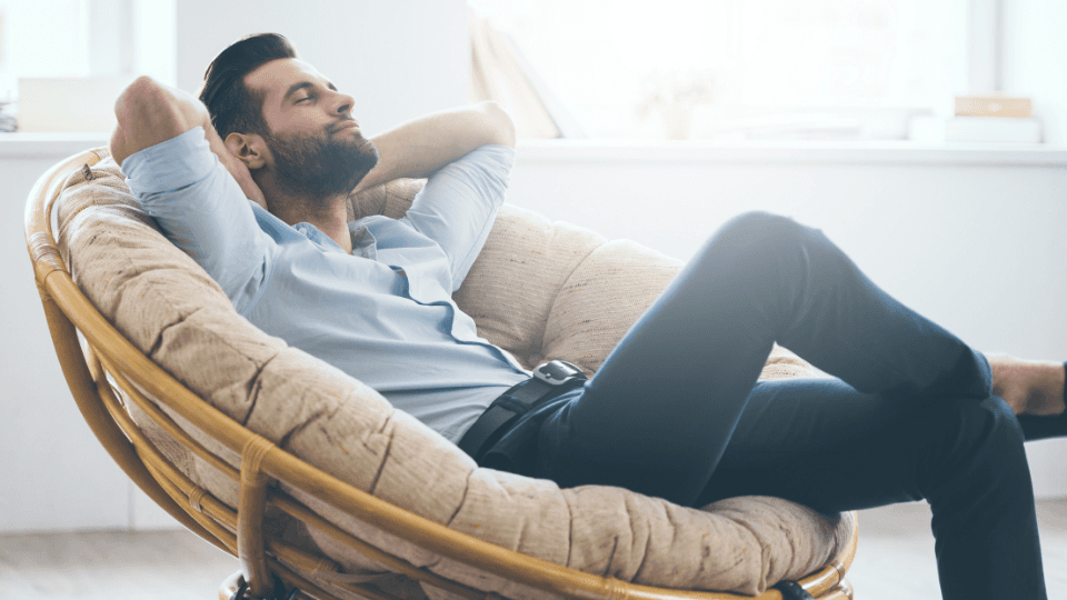 Man laying on a chair with arms behind head relaxing