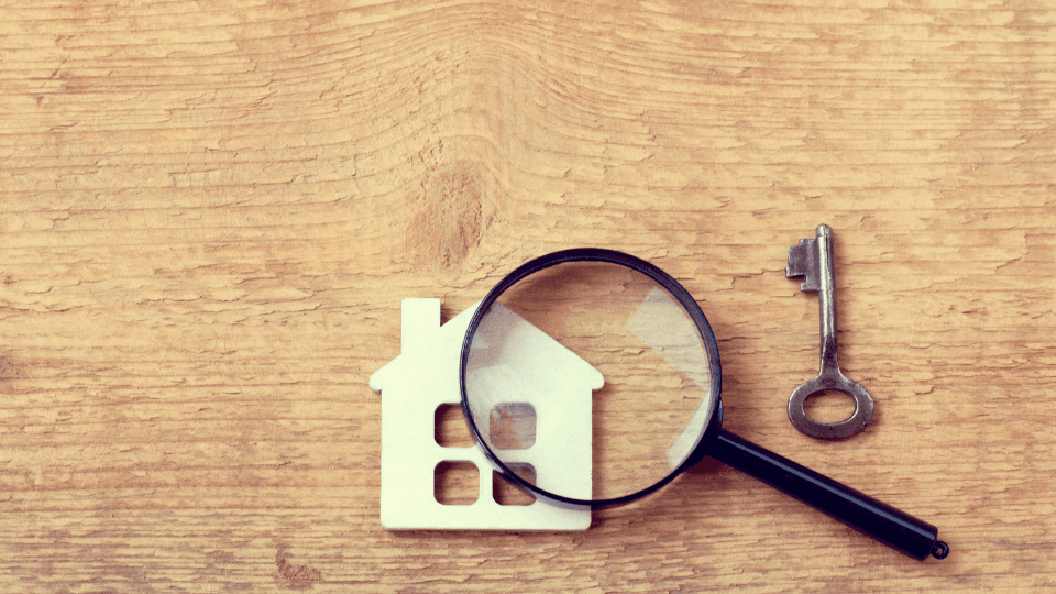 House, microscope and key on a wooden background