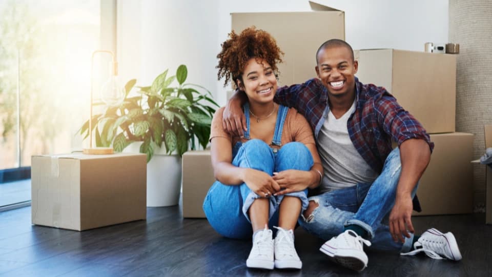 couple sitting on the floor with moving boxes
