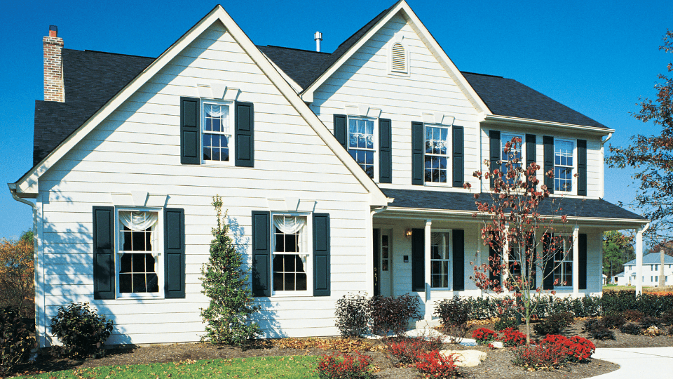 White house with green shutters and plush lawn