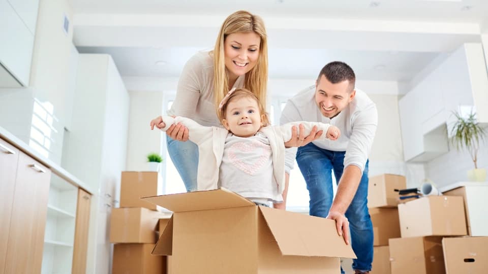Woman and man pushing a baby in a box