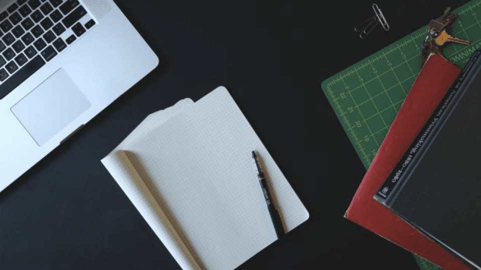 Laptop, Notebooks and pen on black desk